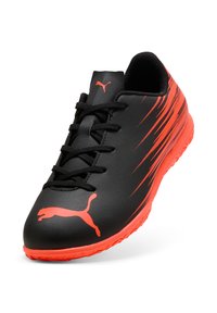 Schwarzer Sportschuh mit roten Akzenten und Streifen, mit strukturiertem Obermaterial, Schnürdesign und geformter Gummisohle. Puma-Logo sichtbar.