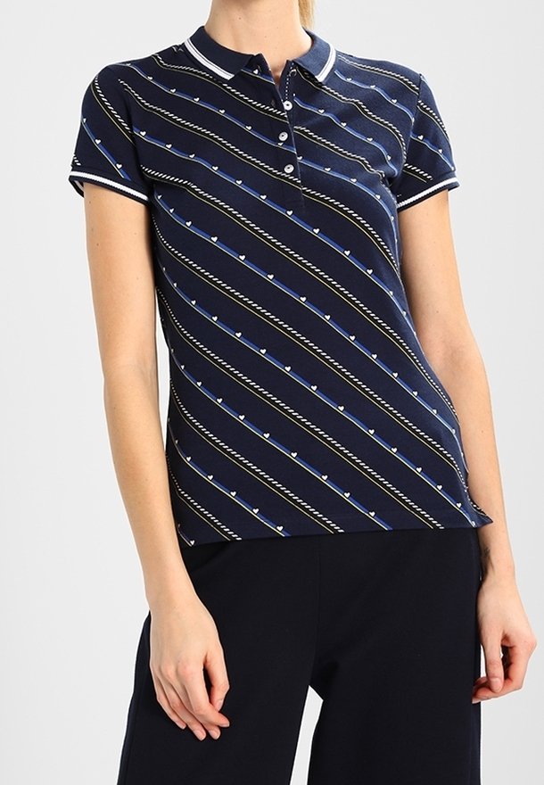Polo blu navy con bordi bianchi, caratterizzato da strisce diagonali e piccoli motivi a cuore. Maniche corte e bottoni al colletto.