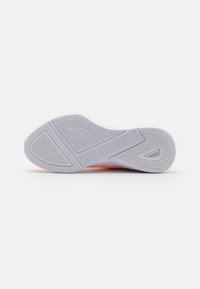 Sole di una sneaker con un design in gomma grigia texturizzata, caratterizzata da scanalature diagonali, accenti rosa e un logo impresso di lato.