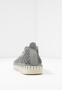 Scarpa slip-on in suede grigio con tomaia testurizzata caratterizzata da motivi a zigzag e suola in gomma bianca. Parte posteriore dotata di un tab per il facile indosso.