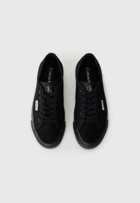 Sneakers neri in tela con punta rotonda, lacci neri piatti, suole in gomma e brandizzazione Calvin Klein sulla linguetta e sull'etichetta laterale.