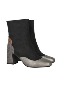 Botas de tobillo de ante negro con puntera metálica plateada y tacón de bloque con patrón. Acento marrón en la parte trasera, con una textura suave.