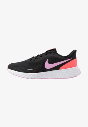 Baskets de sport noires avec le logo Nike rose, accent corail au talon, lacets noirs et semelle blanche texturée.