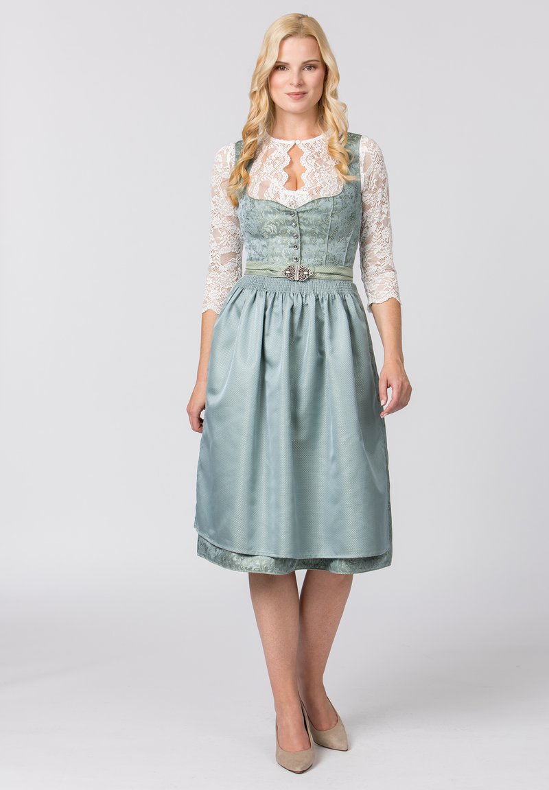 Traditionelles Kleid mit einem taillierten Oberteil aus leicht grünem Stoff, dreiviertellangen Spitzenärmeln, einem plissierten Rock und dekorativen Knopfdetails.