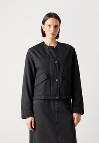 Černá, zkrácená bomber bunda z hladkého, lesklého materiálu s kulatým výstřihem, kovovými knoflíky a dvěma předními kapsami. Minimalistický design.