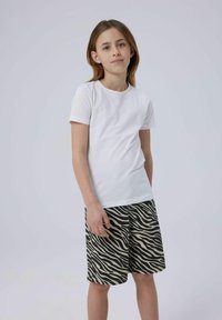 Vit kortärmad t-shirt kombinerad med beige och svarta shorts i zebramönster. Slät bomullstextur, avslappnad passform och standard rund halsringning.