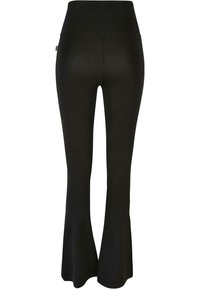 Leggings noirs évasés avec une taille haute, fabriqués dans un tissu extensible. Texture lisse avec un minimum de détails et sans matériel visible.