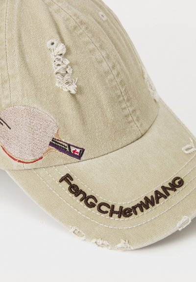Beige verwitterte Kappe mit besticktem Tischtennisschläger-Design und dem Text "FenGCHenWANG" in Braun. Verfügt über ausgefranste Kanten und strukturierter Stoff.