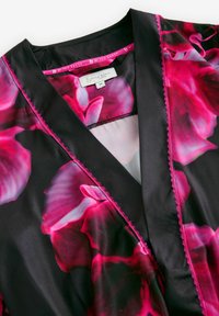 Mustan värinen viitta, jossa on kirkas vaaleanpunainen kukkakuosi. Siinä on satiininen rakenne, viistonnakkana, sekä erottuva vaaleanpunainen ommel reunoilla.