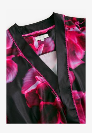 Schwarzes Kleidungsstück mit lebhaftem pinkfarbenen Blumenmuster, aus satinartigem Material, mit einem markanten Kragen und kontrastierenden pinken Nähten an den Rändern.