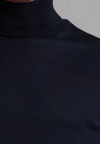 Marinefarbener Rollkragenpullover mit gerippter Textur, enger Passform und hohem Kragen. Aus weichem, dehnbarem Stoff gefertigt.