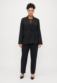 Μαύρο σακάκι με διπλό κούμπωμα, δύο μπροστινές τσέπες, σε συνδυασμό με ταιριαστά παντελόνια και μαύρες μυτερές γόβες. Απαλή υφή υφάσματος.