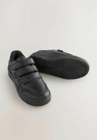Sneaker nere con tre cinturini in velcro, tomaia in pelle sintetica liscia, dettagli perforati e suola in gomma testurizzata.