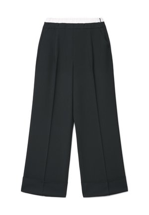 Pantalon noir à jambes larges avec taille élastique blanche et poches latérales, doté de plis à l'avant et d'ourlets retroussés.