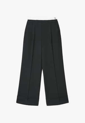 Pantalon noir à jambes larges avec taille élastique blanche et poches latérales, doté de plis à l'avant et d'ourlets retroussés.