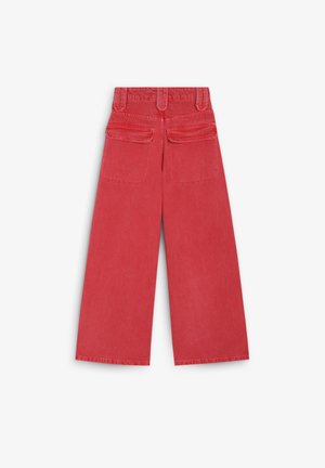 Pantalons larges rouges en coton, avec deux poches arrière et une ceinture à passants. Le tissu a une texture lisse.