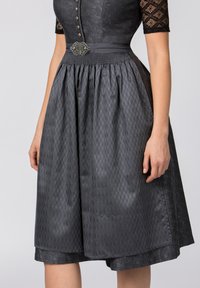 Black dress featuring a textured bodice with buttons, a smooth skirt with a subtle diamond pattern, and a decorative belt buckle at the waist.