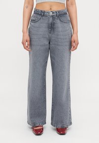 Bredde beinse i lys grå denim, med høy midje, falmet tekstur og tradisjonell fem-lomme-design.