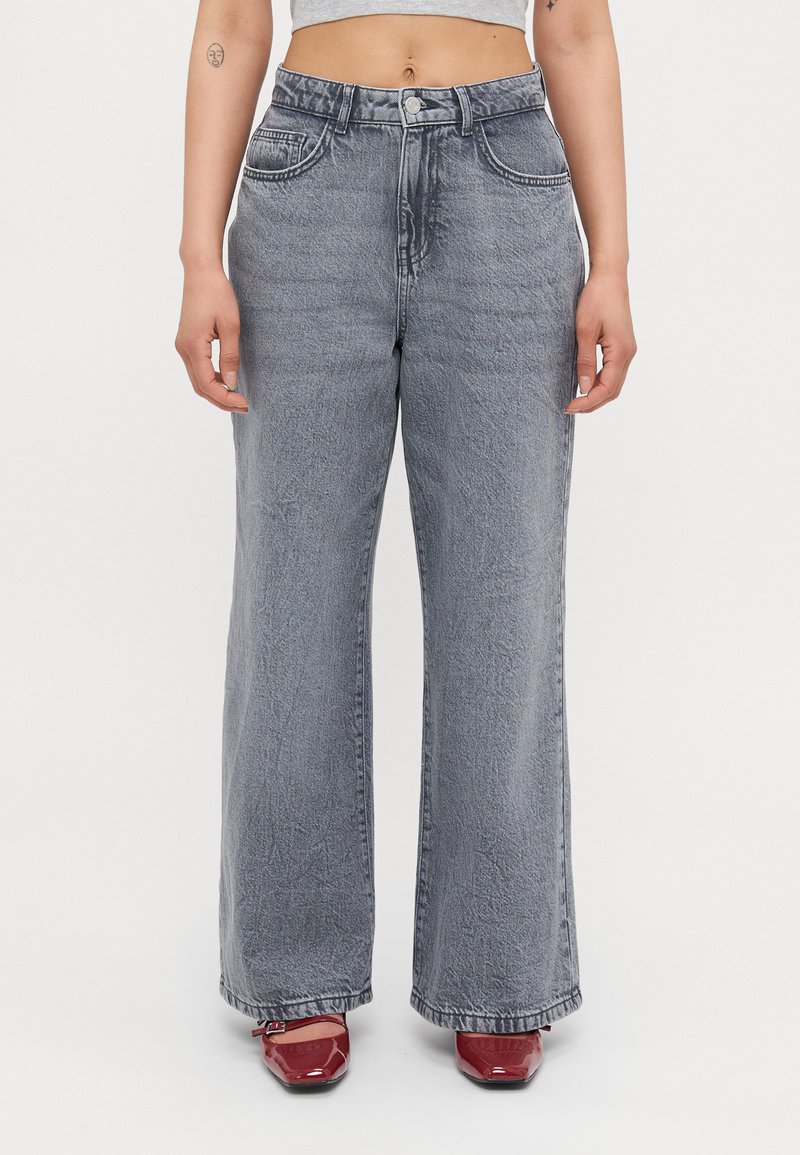 Bredde beinse i lys grå denim, med høy midje, falmet tekstur og tradisjonell fem-lomme-design.