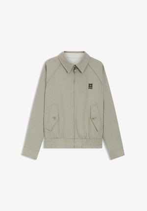 Hellgraue Zip-Jacke mit kleinem Karomuster, Klappentaschen mit Knöpfen, elastischem Bund und schwarzem Hugo-Logo auf der Brust.