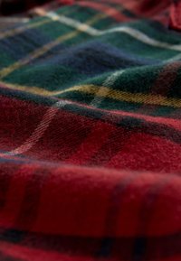 Tessuto a quadri con colori rosso, verde, blu scuro e giallo. Texture morbida con fibre sottili e motivo di tessitura visibile.