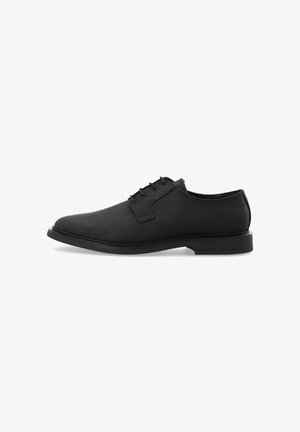 Black leather oxford shoe with smooth texture, round toe, and six eyelet lace-up design. Flat rubber sole with a subtle heel.