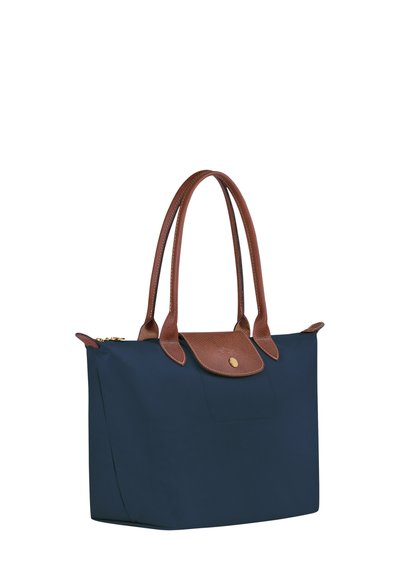 Navy blue tote bag with brown leather accents and handles, featuring a textured finish and a gold snap closure on the front.
