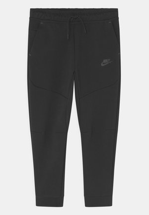 Sorte smalle Nike sweatpants med elastisk talje, snøre, sidelommer og subtil Nike-logo på venstre lår.