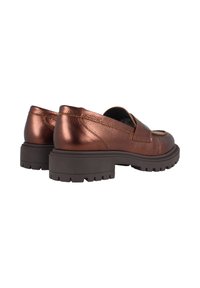 Zapatos slip-on metálicos en bronce con superficie texturizada, punta redondeada y suela gruesa de goma negra con dibujo en relieve.