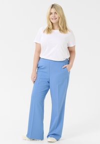 Light blue wide-leg trousers with a smooth texture, front pockets, and a high waist, paired with a plain white t-shirt.