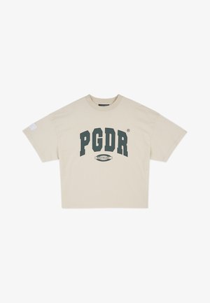 Beżowy T-shirt z krótkim rękawem z dużym ciemnozielonym napisem „PGDR” i małą metką „BUILT TO LAST” pod spodem.