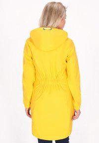 Gul vandtæt jakke med snørelukning i hætten, elastisk talje og lange ærmer; glat tekstur og knælængde design.