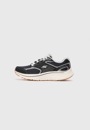 Black athletic shoe with mesh upper, gray accents, and white midsole. Features a lace-up design and textured rubber outsole.