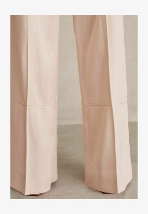 Light pink wide-leg trousers, featuring a textured fabric, seam detailing, and a clean cut at the hem. Suitable for casual or formal wear.