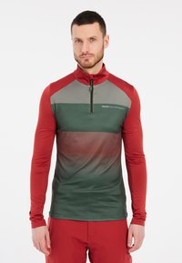 Lange mouw rits-top in groen en rood, met een ruitpatroon op het bovenste deel en een gladde textuur overal.