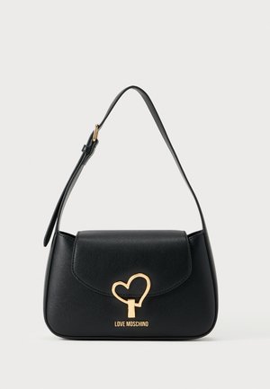 Black leather handbag with a curved shape, gold heart-shaped hardware, and an adjustable shoulder strap. Features logo on the front.