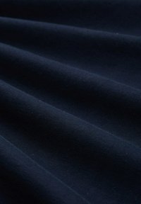 Djup marinblått tyg med en slät textur, som har milda vågor och en subtil lyster, liknande bomull eller en bomullsblandning.