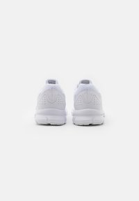 Un paio di scarpe sportive bianche viste da dietro su uno sfondo bianco semplice, che mostrano dettagli testurizzati del tallone e della suola.