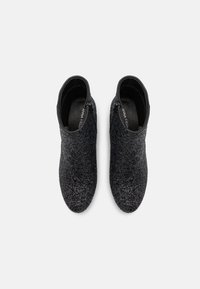 Botine negre cu guler texturat, căptușeală netedă și închidere cu fermoar pe lateral, având o siluetă ajustată și un design cu vârful rotund.