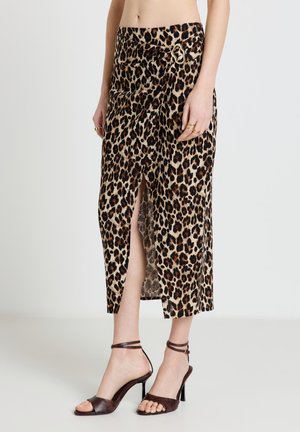 Jupe midi à imprimé léopard avec fente devant, détail boucle dorée, portée avec des sandales à talons hauts à bride cheville marron et des bagues dorées.