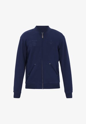 Námořnická bunda na zip z měkké látky se stojatým límcem, dvěma předními kapsami a vyšitým logem kotvy na hrudi.