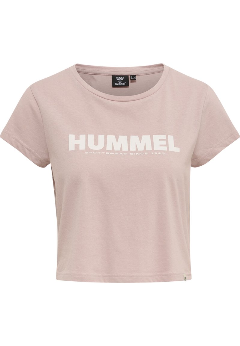Top corto de color rosa claro, hecho de algodón suave, con cuello redondo. Presenta un destacado texto en blanco que dice "HUMMEL" y "SPORTSWEAR SINCE 1923" debajo.