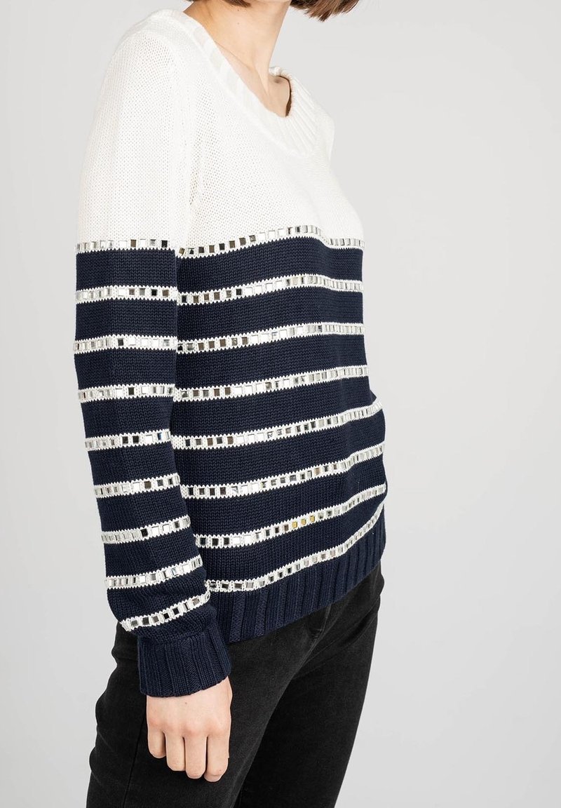 Maglione lavorato a maglia con strisce orizzontali blu navy e bianche, arricchito da dettagli metallici. Collo e polsini a costine. Vestibilità casual e tessuto testurizzato.