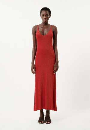 Robe maxi rouge sans manches avec un décolleté en V, présentant un corsage ajusté et un ourlet évasé. Tissu doux et texturé avec un effet de légère brillance.