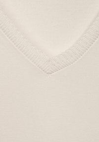 Maglione color crema con scollatura a V caratterizzato da una texture a coste lungo il collo, realizzato in tessuto morbido e liscio con una silhouette aderente.
