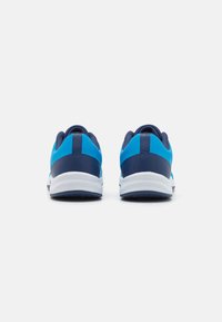Scarpe sportive blu con un design liscio e testurizzato. Presentano un tacco blu navy e una suola bianca, evidenziando colori in contrasto e una forma slanciata.