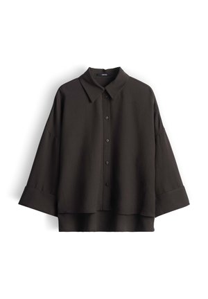 Zwarte oversized overhemd met knopen, brede manchetten en een klassieke kraag, plat gepresenteerd tegen een witte achtergrond.