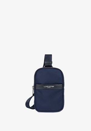 Sac crossbody en nylon bleu marine avec une bande texturée noire et une fermeture éclair. Dispose d'une sangle ajustable et d'un détail logo à l'avant.