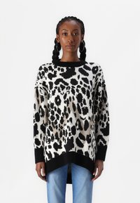 Suéter de punto con estampado de leopardo en blanco y negro, con un cuello negro acanalado y un corte holgado, con un dobladillo trasero más largo.