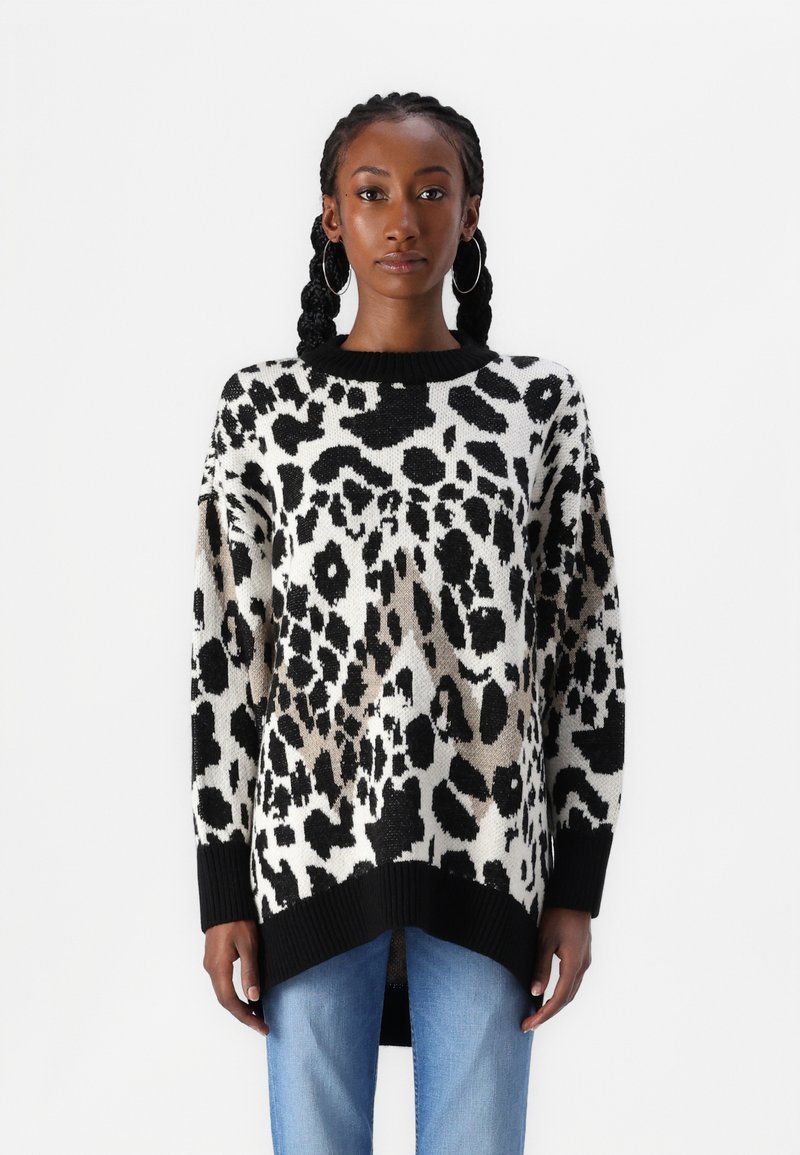 Suéter de punto con estampado de leopardo en blanco y negro, con un cuello negro acanalado y un corte holgado, con un dobladillo trasero más largo.